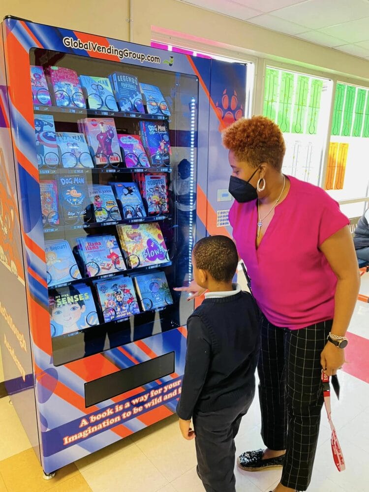 McCullough Academy Principal Sharmayne McKinley introduces the book vending machine to a student.